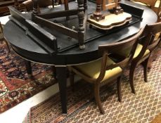 A modern ebonised and silver highlighted extending dining table in the Victorian taste with two
