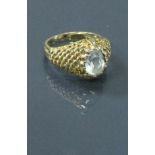 A 9 carat gold ring with aquamarine set stone centre, the shoulders of stylised net design,