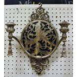 A pair of silver plated wall sconces with pierced lion rampant decoration and tassel drops to the