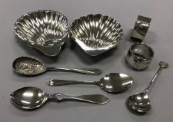 A collection of silver comprising two scallop shell butter dishes, two napkin rings,