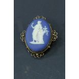 A Wedgwood Jasper ware medallion housed on a 9 carat gold frame as a brooch