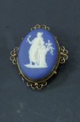 A Wedgwood Jasper ware medallion housed on a 9 carat gold frame as a brooch