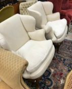 A pair of 19th Century upholstered wing back scroll arm chairs on cabriole supports to pad feet in