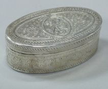 A Continental white metal oval hinged lidded box with engraved decoration,