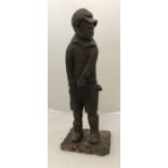 A 19th Century carved wooden figure of a young boy in cap and shorts