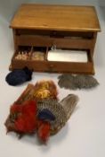 A fly fisherman's three drawer workbox containing an assortment of fly tying materials to include