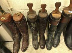 A pair of black and tan leather riding boots with wooden trees,