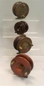 A collection of four wooden fishing reels to include an unnamed 3½" Slater latch Starback,