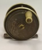 An ebonite and brass trout fly reel depicting a fisherman in relief on the face plate 23/8"