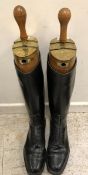 A pair of black leather lace-up riding boots with wooden trees,