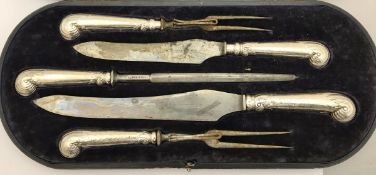 An early 20th Century cased silver mounted pistol grip five piece carving set,