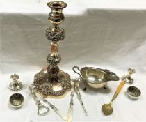 A silver sauceboat, two small silver candle holders, assorted silver and silver plated spoons,