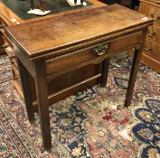 A George III mahogany fold-over tea table with single frieze drawer on square chamfered and moulded