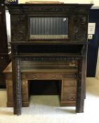 A Victorian Gothic Revival fire surround with mirrored upper section and lion mask ring