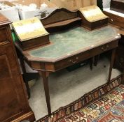 An Edwardian mahogany Carlton House style writing table with painted stationery compartments and