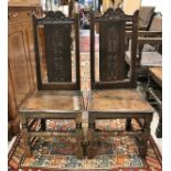 A pair of 18th Century Provincial oak hall chairs with carved backs and panel seats on turned and