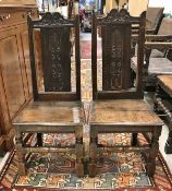 A pair of 18th Century Provincial oak hall chairs with carved backs and panel seats on turned and
