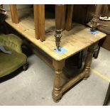 A pitch pine kitchen table, the plank top on turned legs united by a central stretcher,