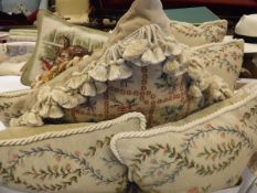 A box containing various needlework scatter cushions with floral decoration