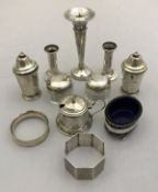 A collection of silver wares to include a pair of silver peppers, silver napkin ring,