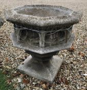A composite stone urn of octagonal form with gothic style design