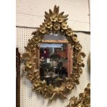 A giltwood and gesso framed wall mirror decorated with floral sprays in the rococo manner