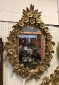 A giltwood and gesso framed wall mirror decorated with floral sprays in the rococo manner