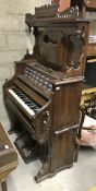 A late 19th Century American walnut cased pedal organ with candle stands, carrying handles,