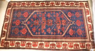 A Turkish rug, the central panel set with elongated lozenge medallion on a blue ground,