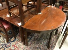 A 19th Century mahogany d-end dining table with two d-end sections with two single drop leaf