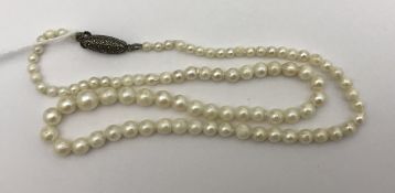 A single strand graduated pearl necklace with silver clasp