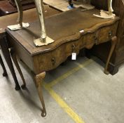 A 1920's walnut desk, the rectangular shaped top inset with tooled rexine, above three drawers,