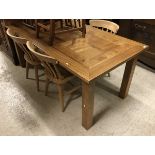A modern rectangular extending farmhouse style dining table with two leaves, on square supports,