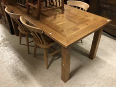 A modern rectangular extending farmhouse style dining table with two leaves, on square supports,