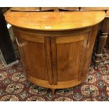 A 19th Century Scandinavian pine cupboard of demilune form the plain top over two doors on simple