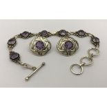 A modern silver and amethyst bracelet and earrings set