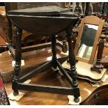 A 20th Century oak triple drop leaf occasional table on splayed turned supports to block feet