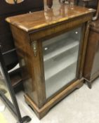 A Victorian walnut side cabinet with single glazed door enclosing two shelves,
