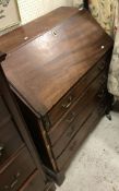 A late George III mahogany bureau with sloping fall enclosing a fitted interior over four long