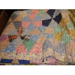 A mid-20th Century patchwork quilt in pink, yellow, green,