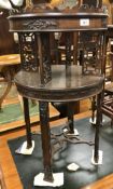 An Edwardian mahogany two tier occasional table with carved floral and fretwork decoration