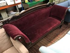 A Victorian carved mahogany framed scroll arm sofa on octagonal faceted baluster supports to