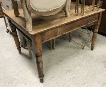 A late Victorian farmhouse pine kitchen table with single end drawer on turned legs