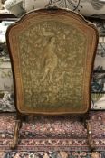 An early 20th Century walnut framed fire screen in the Louis XV taste with gros and petit point