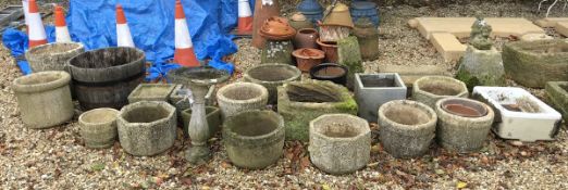 A large collection of various natural stone and reconstituted stone planters,