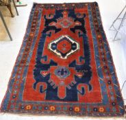 A Caucasian rug, the central panel set with central medallion on a dark red and blue ground,
