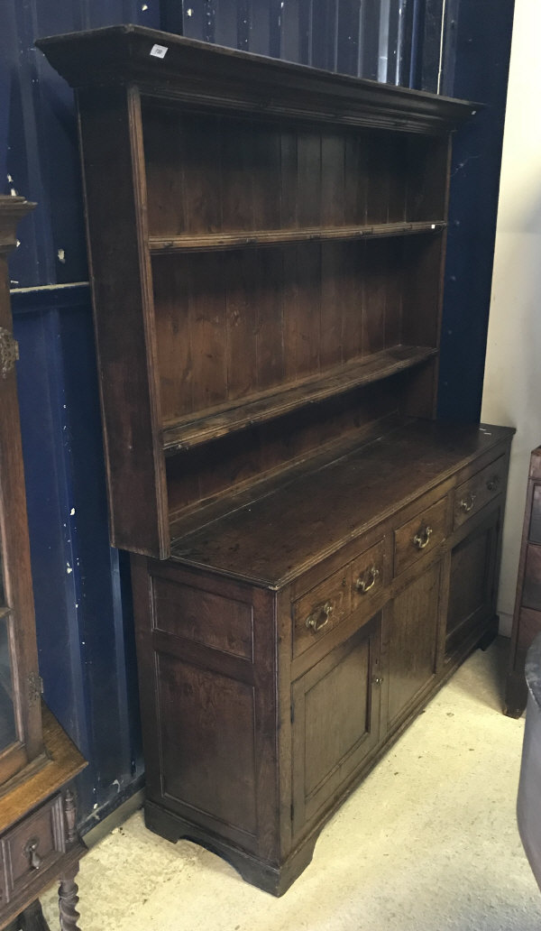 A 19th Century oak dresser the boarded two tier plate rack over three drawers and two cupboard