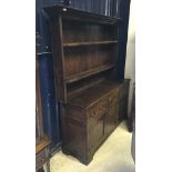 A 19th Century oak dresser the boarded two tier plate rack over three drawers and two cupboard