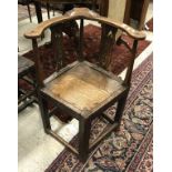 An 18th Century oak corner chair with panelled seat