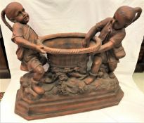 A terracotta jardinier as two Oriental children holding aloft a basket,